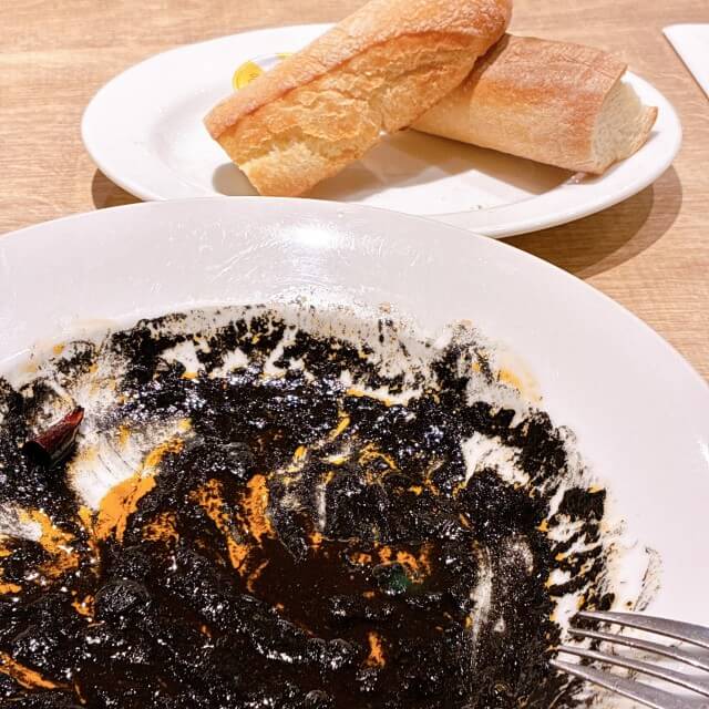 イカ墨のソースが余ったお皿と、追加注文したパン