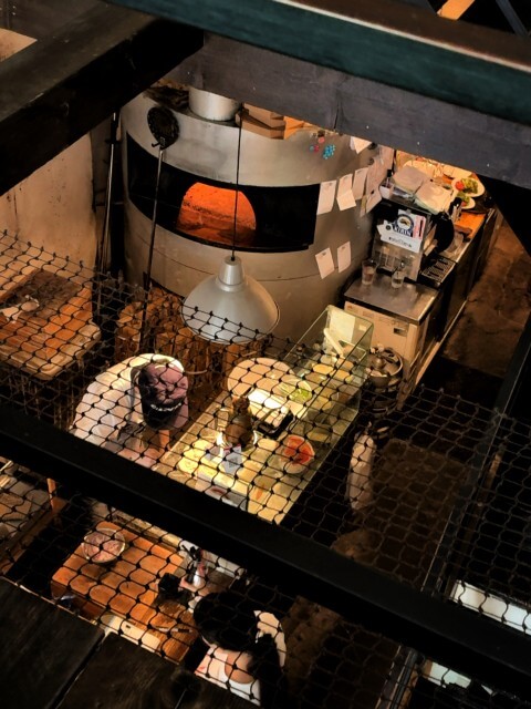 ピザ窯と調理台がある厨房を上から見下ろした様子