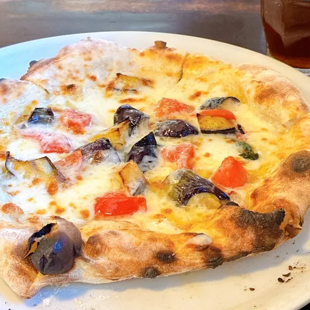 焼き色のついた生地に、ナスとトマト、チーズののったピッツァ「メランツァーネ」