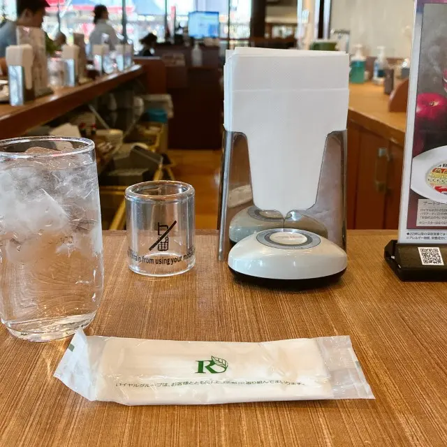 テーブルに水のグラス、ナプキン立てが並ぶ写真