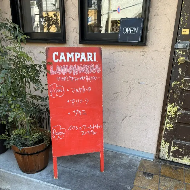 赤い立て看板に書かれた、ピザやパスタのランチメニュー