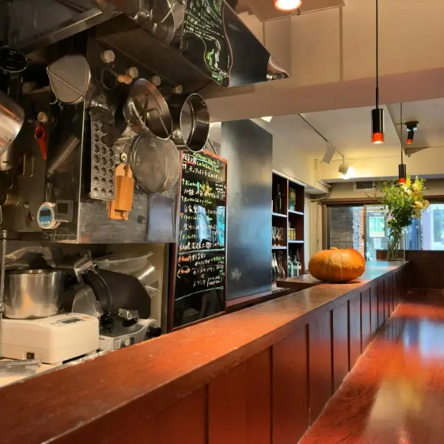 木目調の長いカウンターがある店内の風景と、その上に置かれた大きなカボチャ